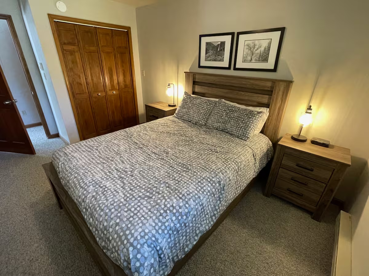 Bedroom with a wood headboard, a closet and two framed black-and-white prints above the bed