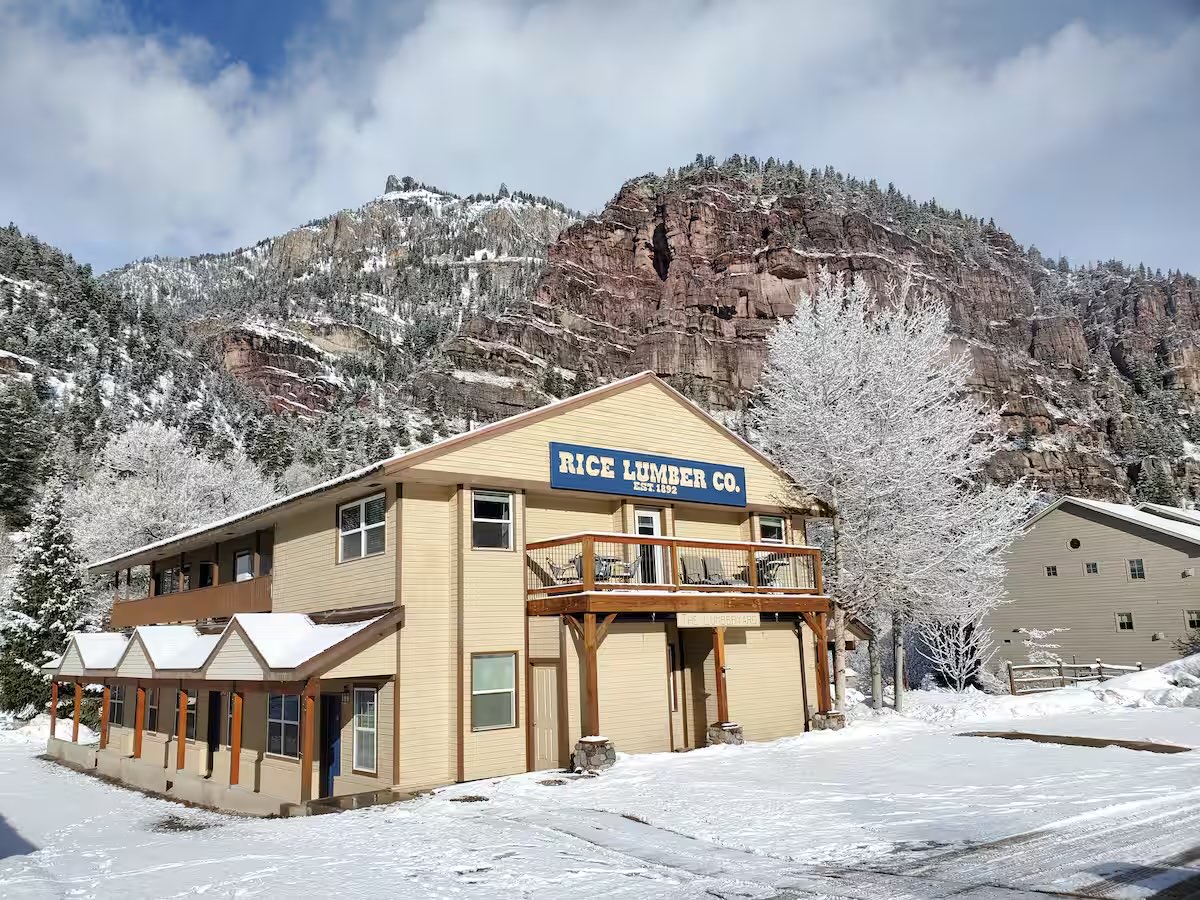 The restored Rice Lumber Co. building in snow, below the canyon wall