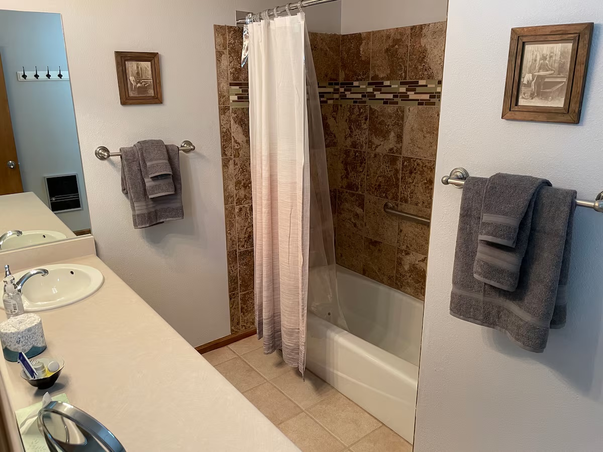 Bathroom with a double vanity and a tiled tub and shower