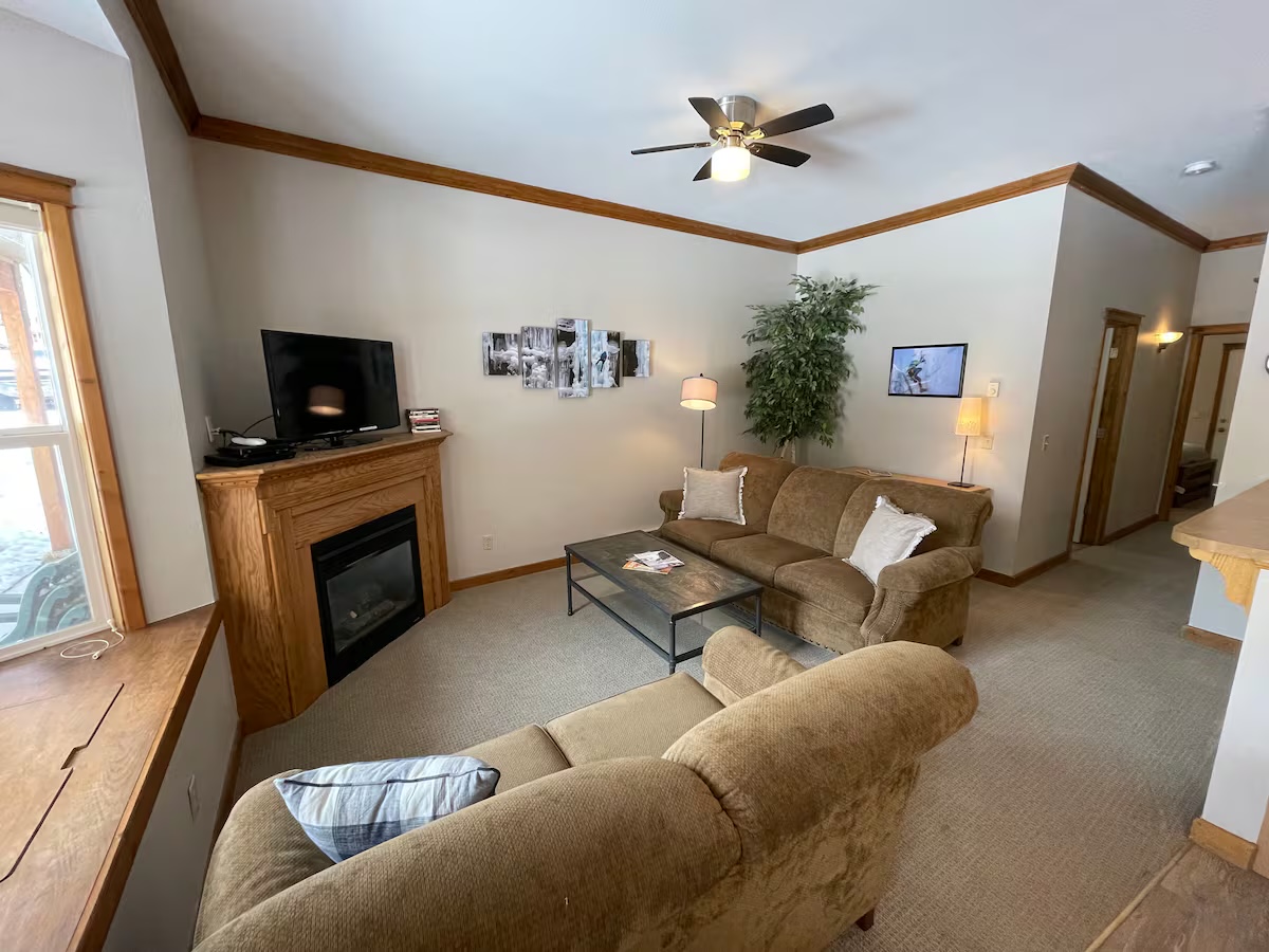 Living room with a gas fireplace, a television on the mantel and ice-climbing canvases on the wall